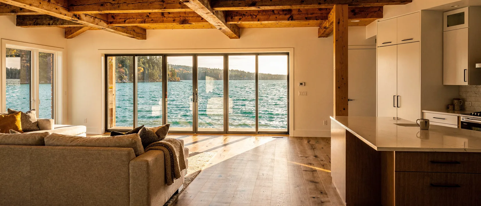 Open-concept lake house interior with exposed beams and lake view